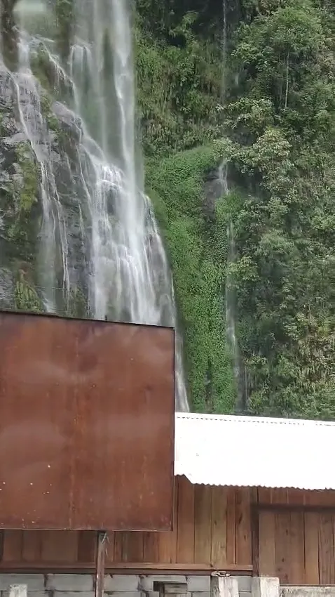 Waterfall beside a mountain road on a journey toward Mechuka